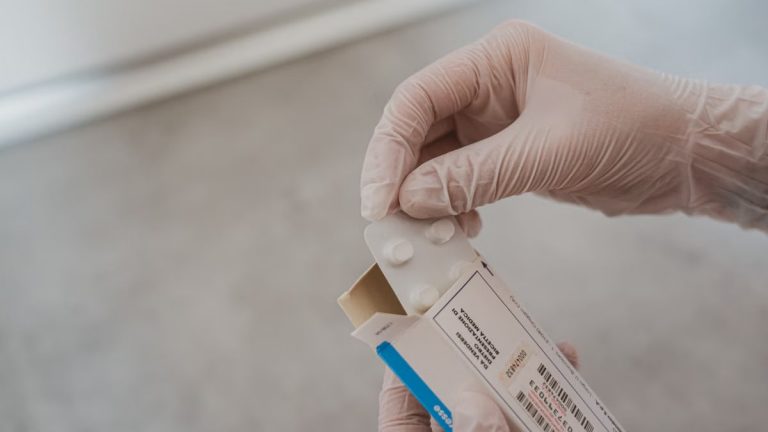 Close-up of hands in gloves handling medication blister pack, ensuring safety and hygiene in healthcare.
